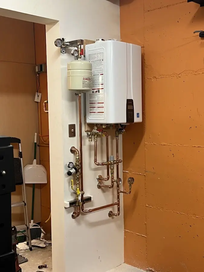 Plumbing technician inspecting water heater connections in Marysville